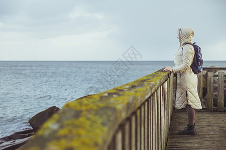 孤独的妇女站在丹麦的码头上图片