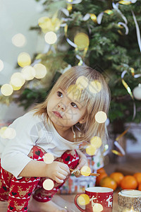 在圣诞树附近玩耍的迷人的孩子乐趣宝贝童年花环松树假期新生家庭金发新年图片