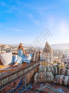 穿着衣服在屋顶上衣着的年轻女子 在土耳其的景色令人惊叹女孩旅游时间沙发旅行天空裙子岩石飞机日落图片