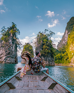 在泰国豪索克湖旅行时 在龙尾船前的一对夫妇图片