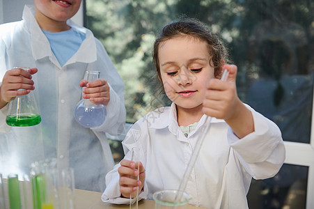美丽微笑的小女生在学校实验室享受化学课 孩子们进行化学实验图片