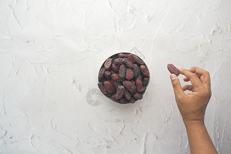 用手从碗里摘干椰子水果图片