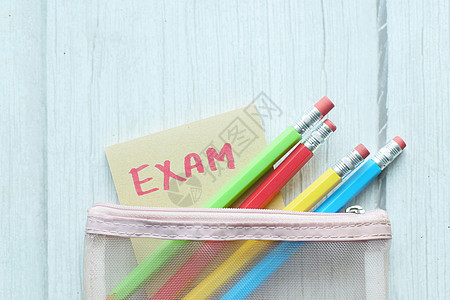 颜色背景上的粘贴纸条和铅笔中的考试单词学校办公室案件作品工具剪辑童年笔记教育黄色图片