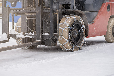 有链子的拖拉机轮子 拖拉机或装载机在湿滑的雪路上 装载机使用防滑链在雪地上行驶天气车辆橡皮金属驾驶安全防滑记录汽车运输图片