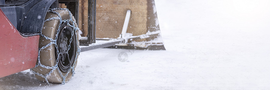 有链子的拖拉机轮子 拖拉机或装载机在湿滑的雪路上 装载机使用防滑链在雪地上行驶季节记录卡车汽车运输防滑安全金属车辆机器图片