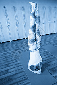 瑜伽练习和站在头上的女人 身心健康 快乐生活和幸福的概念平衡姿势手臂女士房间身体蓝色杂技女孩训练图片