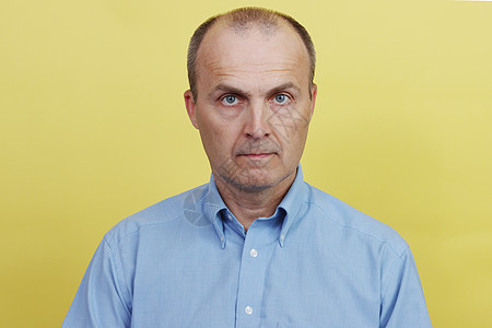 一个穿着蓝衬衫的英俊老人的全脸肖像成功衬衫成人工作室纽扣背景生意扣子蓝色黄色图片