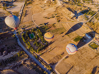 在土耳其卡帕多西亚州戈雷梅的Nevsehir仙子烟囱谷飞过 飞过有色热气球 对地下城市和气球旅游进行了惊人的全景无人驾驶飞机观察图片