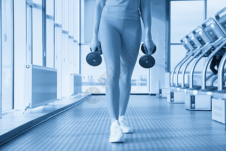 健身房里身体健康的女人 有哑铃准备加强她的手臂和二头肌重量活力活动举重运动员日落相机训练女士力量图片