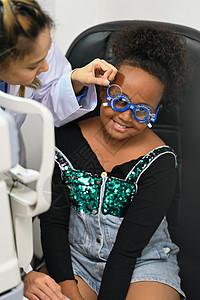 微笑的女孩与眼科医生一起检查眼睛视力是否有眼镜 眼睛健康检查 眼科概念图片