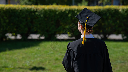 一个女人把她的毕业帽扔在蓝天上女孩研究生仪式帽子知识学生愿望学士校园中学图片