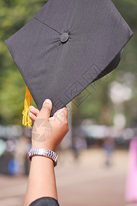 学生在黄背景的入门成功期间手握着帽子庆典学校教育黄色学习研究生快乐仪式证书毕业典礼图片