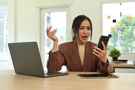 愤怒的女人盯着手机屏幕 对互联网连接速度或低信号设备问题感到恼火图片