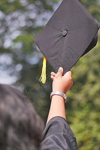 学生在黄背景的入门成功期间手握着帽子男性灯光毕业典礼黄色证书学习仪式黑色学校大学图片