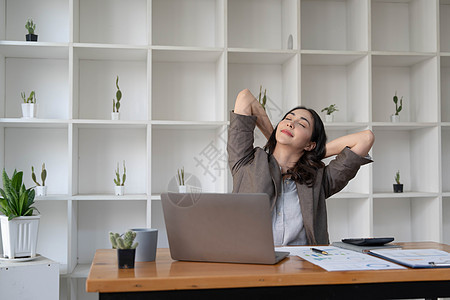 亚洲女商务人士伸出双臂来放松疲劳的肌肉 免得整天在办公室办公桌工作 忙着工作电脑压力身体疾病职场笔记本桌子手腕商业商务图片