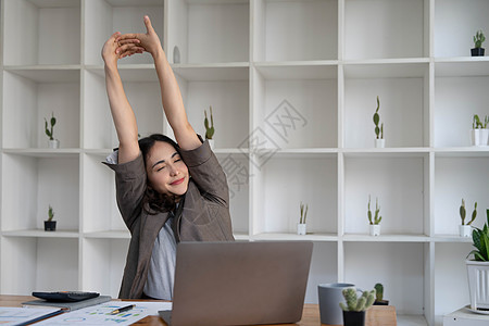 亚洲女商务人士伸出双臂来放松疲劳的肌肉 免得整天在办公室办公桌工作 忙着工作疾病压力桌子电脑姿势人士职场手臂疼痛员工图片