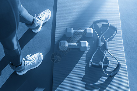 女人脚在垫子旁边 有扩张器和哑铃鞋类女孩臀部健身房跳跃训练屁股音调生活运动员图片