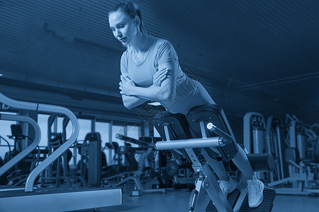 体育年青运动妇女健身锻炼机锻炼女孩健身房机器健美手臂微笑培训师腹肌身体音调图片