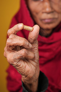 拥有草药胶囊的高级亚洲裔女性图片