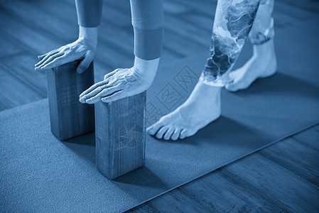 从事瑜伽的妇女使用手用木制的木棍 脊椎锻炼和肩膀灵活度道具蓝色女士健身房活动生活身体地面积木姿势图片