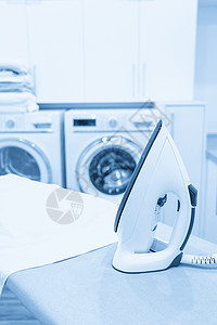 在洗衣房用白衬衫熨衣板上的铁白色衣服机器洗涤房间蒸汽工作木板家庭作业棉布图片