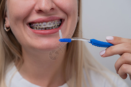 白种女人用刷子用牙套擦牙 用剪裁的肖像喜悦呼吸卫生牙刷牙医矫正病人快乐结盟牙科图片