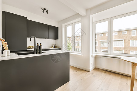 一个有黑柜子和一个大窗户的厨房台面黑色壁炉建筑学风格住宅财产木地板房子橱柜背景图片