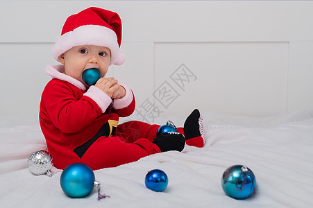 穿成圣诞老人的宝贝男孩正在床上玩圣诞装饰品季节柔软度男婴家庭童年新年喜悦儿子假期孩子图片