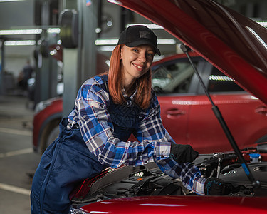一名身穿内衣的女汽车机械师正在修理一辆汽车女孩机器机械员工技术员车站扳手工作服工程师服务图片
