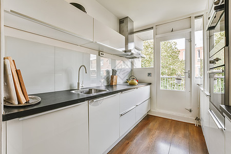一个有水槽和窗户的白色厨房房子奢华建筑学家具车辆地面烤箱火炉柜台血管图片