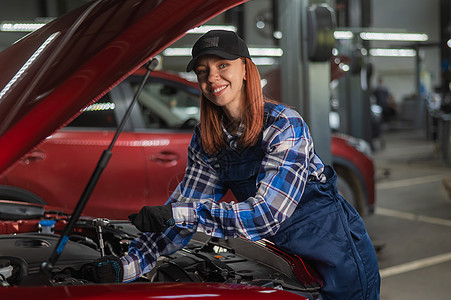 一名身穿内衣的女汽车机械师正在修理一辆汽车职场检查女性女孩工作车库机器服务发动机员工图片