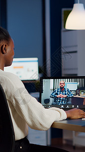 手持耳机的非洲经理在摄像机上挥手说话商业互联网电脑讨论办公网络工人职场营销瘫痪图片