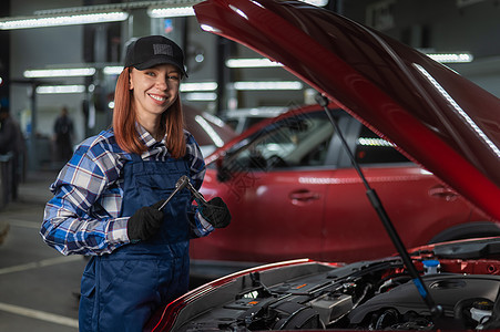 一名身穿内衣的女汽车机械师正在修理一辆汽车诊断女性工作机器工程师修理工作坊车库车辆工作服图片