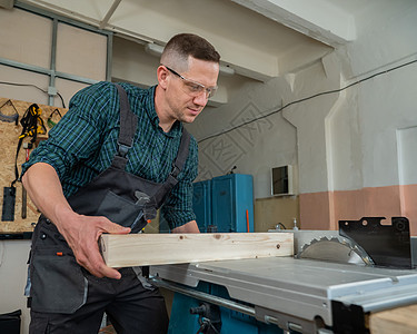 木匠在圆形机器上切开木板承包商工人木工安全工作木头工具爱好男性乐器图片