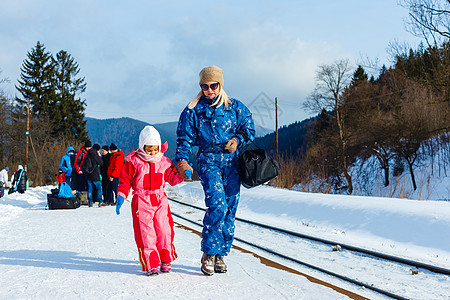 在大雪降临后 一个女人与女儿一起等待她的火车到达那里站立城市旅行交通工具天气运输民众首都女士母亲图片