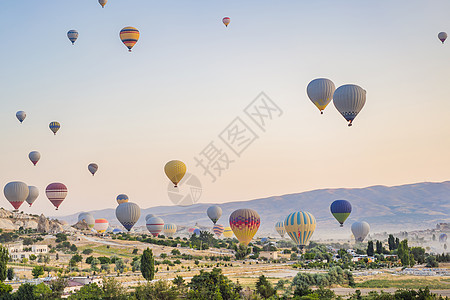 由土耳其卡帕多西亚上空飞来的多彩热气球太阳日出石头岩石飞机爬坡火鸡场景土地侵蚀图片