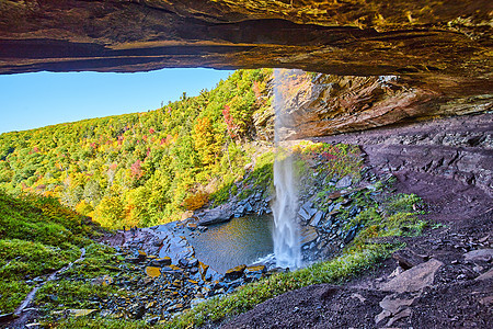大瀑布的背后 巨大的瀑布倒在悬崖上 露开一眼森林山和小游客图片