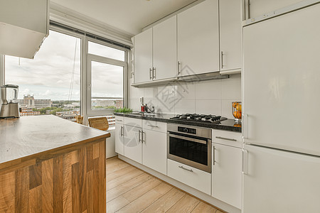 厨房 有白色的柜子和一个大窗户烤箱橱柜器具洗碗机装饰柜台火炉房间风格地面图片