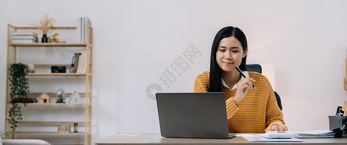 年轻的亚洲女性在家里处理财务文件 先用计算器计算 然后再通过电话在线缴税 千禧一代女性规划预算很高兴找到经济省钱的机会会议商业员图片