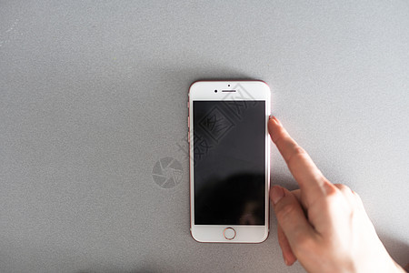 使用橙色墙上孤立的智能手机的女人手的特写 显示现代智能手机空白屏幕的女性手 拿着手机的女商务人士用指纹解锁图片