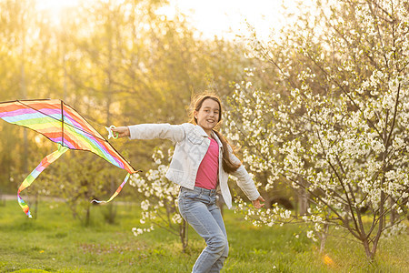 童年 儿童节 小姑娘在春天带着风筝幸福场地竞赛温暖足球友谊孩子们运动孩子公园图片