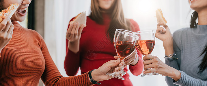 与朋友或同事一起参加节日派对的欢乐时光 在圣诞节举行香槟和在家吃比萨饼庆祝会时聚集一堂金子朋友们饮料假期女士欢呼友谊女性酒精原野图片