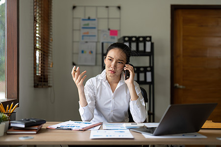 在办公桌的笔记本电脑上 愤怒 打电话和压力很大的亚洲女性在商务电话中谈论税务 审计和合规电子邮件 员工在公司网站上疯狂工作 互联图片