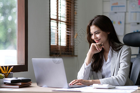 在办公室的笔记本电脑上工作的年轻女子 亚洲女商务人士坐在她办公室的工作场所 美丽的自由职业者女性在她家在线工作居家职业技术妈妈生图片