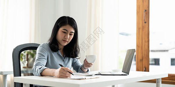 商业亚洲女性会计财务概念 会计使用计算器计算在办公室工作的笔记本电脑图片