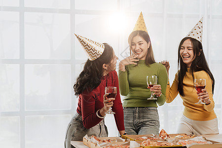 与朋友或同事一起参加节日派对的欢乐时光 在圣诞节举行香槟和在家吃比萨饼庆祝会时聚集一堂奢华眼镜酒精新年女孩假期女士团体朋友们幸福图片