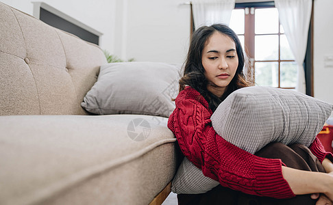 悲伤地独自坐在沙发上 带着悲伤的心情坐着女性悲哀房间情感孤独长椅成人思维疼痛压力图片