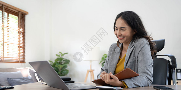 在她的工作站上使用笔记本电脑工作的亚洲年轻商业女性的肖像 商界人士员工自由在线报告营销理念互联网成人工人商务女孩经理管理人员电话图片