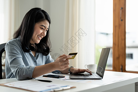 持有信用卡并在笔记本电脑上打字进行在线购物和支付的亚洲女商务人士在互联网 在线支付 商业金融和技术概念上进行购买图片