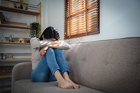 年轻孤独迷人的亚洲女人在沙发上哭泣 感到悲伤 疲倦和担心在家里孤立无援的抑郁症 心理健康和封锁 压力 失业和伤心欲绝的概念沮丧痛图片